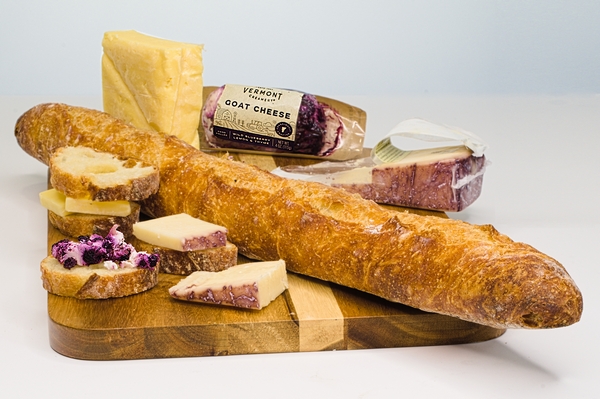 Charcuterie featuring a baguette with blueberry cheese and Merlot soaked cheese