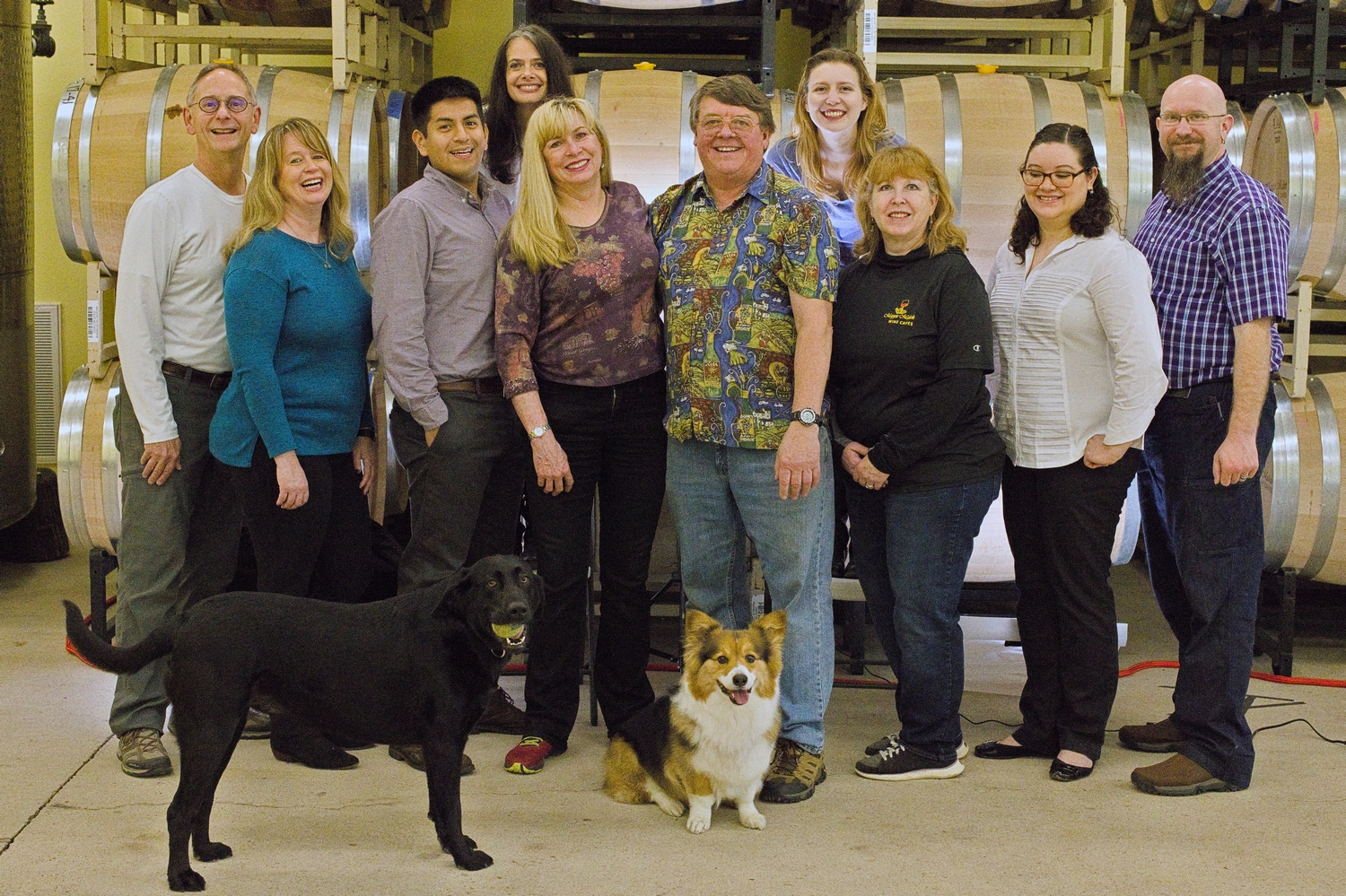 Group picture of employees at Maggie Malick wine caves along with two dogs