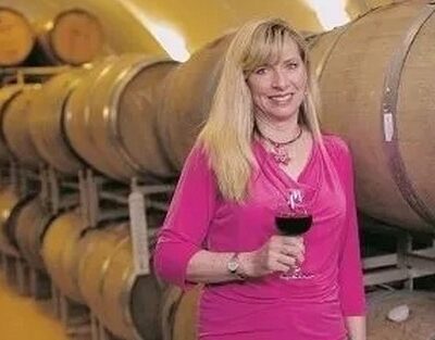 Maggie Malick holding a wineglass in the wine cave